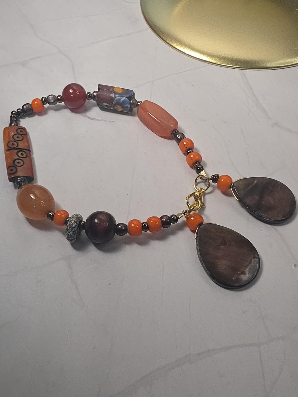 Bohemian-style beaded bracelet featuring vibrant orange and brown tones accented